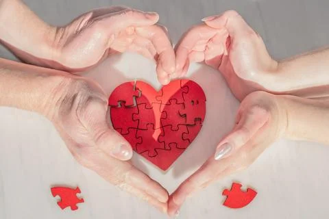 A heart is surrounded by supportive gestures of caring from female, male hand Stock Photos