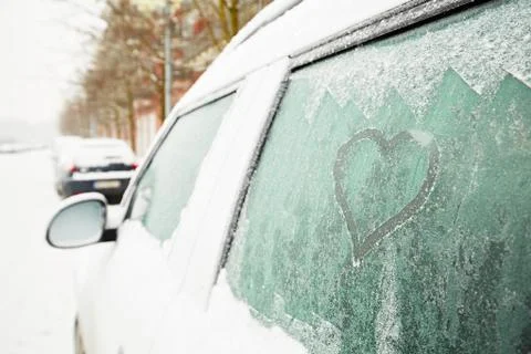 Heart symbol on frozen window of the car Stock Photos