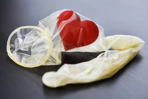 Heart in used condom Stock Photos