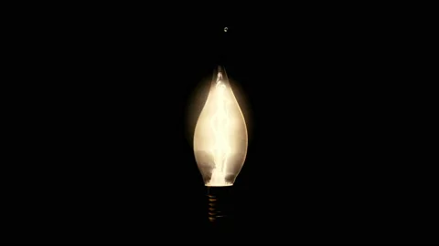 The heartbeat is transmitted by light from a light bulb on a black background Stock Footage 100863151