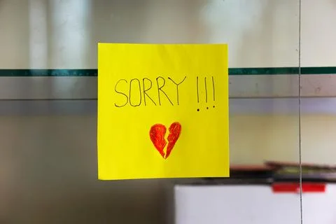 A heartfelt note on a yellow sticky note expresses deep remorse with a brok.. Stock Photos