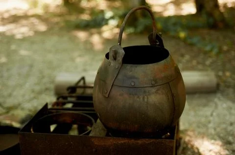 Hearth in the open air.Old rusty pot. Historical detail Stock Photos