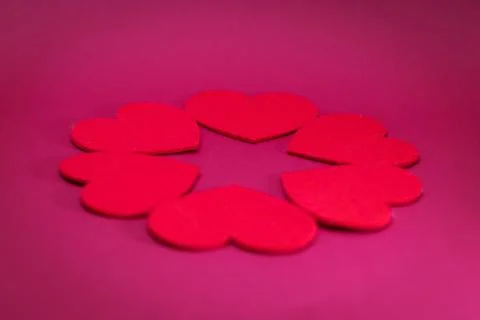 Hearts are laid out in a circle on a pink background Stock Photos