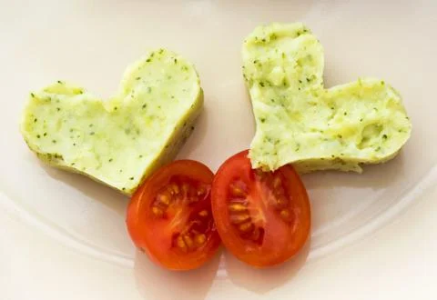 Hearts of mashed potatoes with broccoli and cherry tomatoes Stock Photos