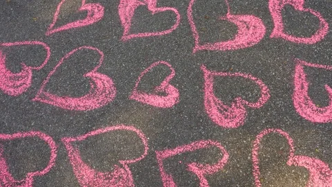 Hearts pattern of many pink hearts drawn on grey texture of sidewalk Video stock 114383506