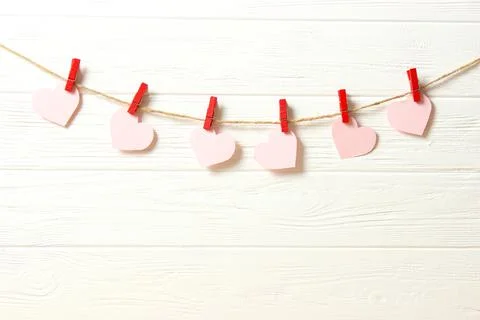 Hearts on a thread on a colored background. Stock Photos