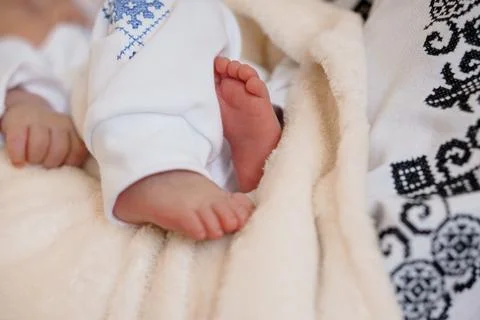 A heartwarming close-up captures tiny newborn baby feet gently enveloped in a 库存照片