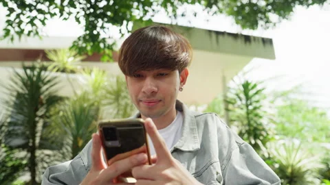 A heartwarming close-up as a man uses his phone, adorned with a radiant smile. Video stock 249592361
