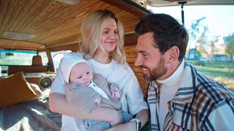 Heartwarming moment inside a camper van, the father gently interacts with the Stock Footage 269558581