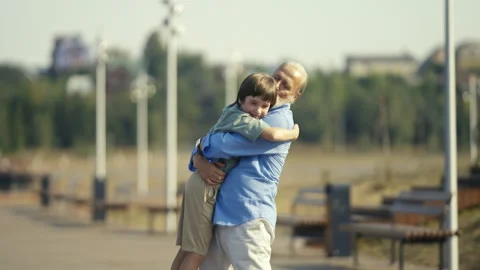 A Heartwarming Warm Embrace Shared Between Grandparent and Grandchild in Park Stock Footage 312985442
