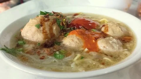 Hearty meatballs float in rich broth with chopped green herbs. 002A 스톡 동영상 335119357