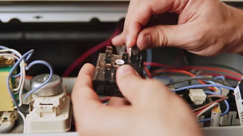 Heat control knob on disassembled electric stove and connecting wire close up. Stockbeeldmateriaal 329226851
