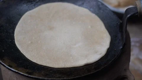 Heat a flat pan, place rolled dough, flip as bubbles form 스톡 동영상 289469506