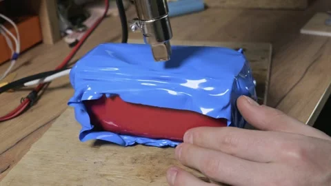 Heat Gun Shrinking Blue Plastic Sleeve On Battery Pack In Workshop Stock Footage 329677869