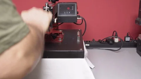 Heat press machine. Man pressing the transfer element on a t-shirt. Dolly shot. Stock Footage 101258677