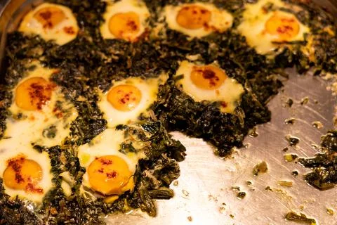 Heated buffet container with Over easy eggs with Spinach and Garlic Stock Photos