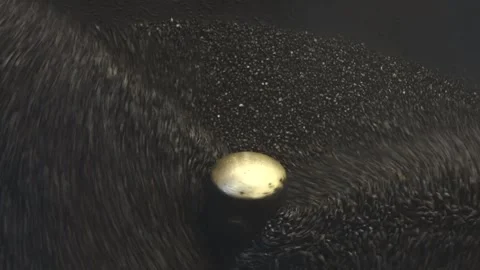 Heated churning black pebbles for roasting chestnuts close up Video stock 297930128