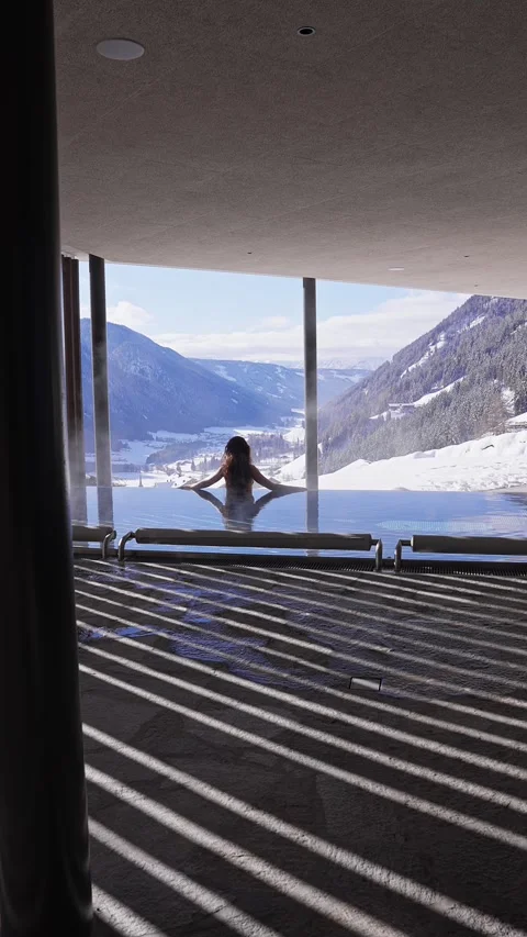 Heated indoor infinity pool with Alpine valley and church steeple Stock Footage 331962228