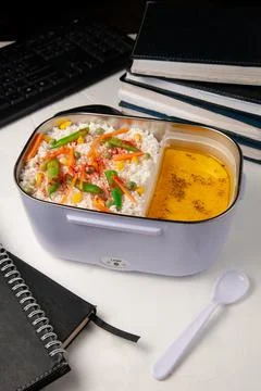 Heated lunch box for carrying and storing food. On the office table. Nearby i Stock Photos