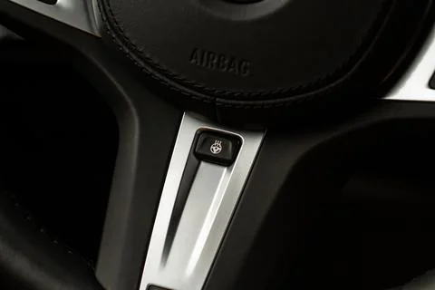 Heated steering wheel switch. Steering wheel heating control panel close up v Stock Photos