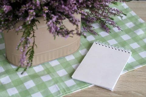 Heather mockup. notebook with an empty cover lies on the table next to a bouquet Stock Photos