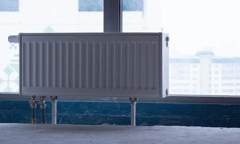 Heating battery opposite the window. Heating system installation concept. Foto stock