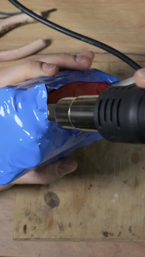 Heating Blue Shrink Wrap On DIY Battery Pack With Heat Gun Stock Footage 329919564