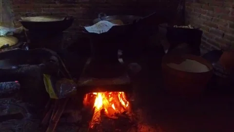 Heating dough on a fire to make spaghetti on Java Indonesia Stock Footage 86506932