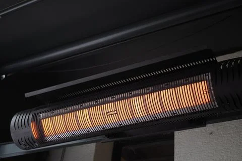 Heating element mounted in outdoor space during evening time Stock Photos