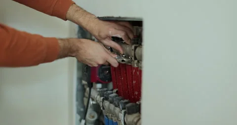 Heating engineer installing modern heating system for underfloor heating. Stock Footage 286136850