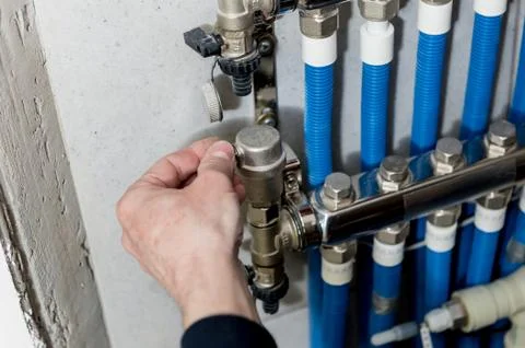 Heating engineer installing modern heating system in boiler room. Stock Photos