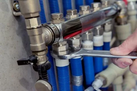 Heating engineer installing modern heating system in boiler room. Stock Photos