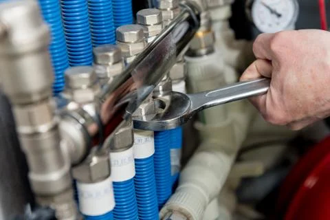 Heating engineer installing modern heating system in boiler room. Stock Photos
