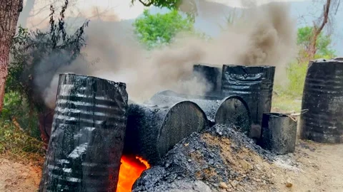 Heating up with fire taarcoal for raod constrction Stock Footage 279800125