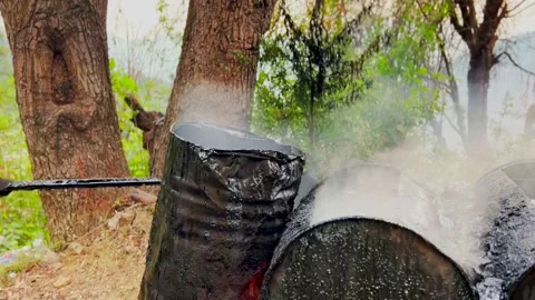 Heating with fire taarcoal for road construction in hill station 動画素材 279800407