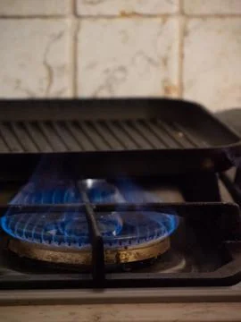 Heating a grill above the fire in the kitchen Stock Photos