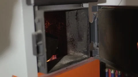 Heating the house with a solid fuel boiler. Wood are burned in the furnace of Stock Footage 234873201