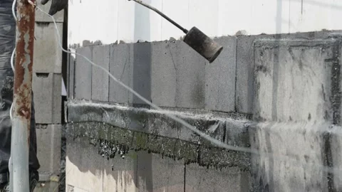 Heating the insulation with an open fire. applying asphalt strips to the wall Stock Footage 239004934