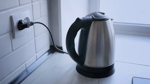 Heating of kettle with water close-up on white wooden table in room. Close up Stock Footage 119820774