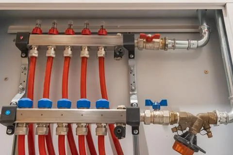 Heating manifold with multiple connected pipes inside cabinet. Fotos Stock