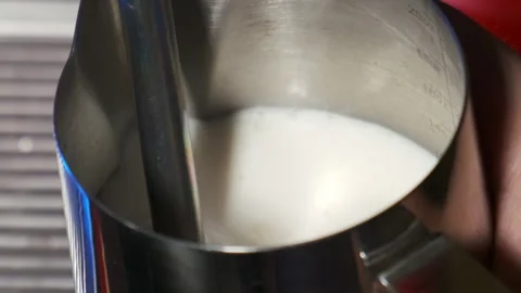 Heating milk in a pitcher. Slow motion. Stock Footage 183968566