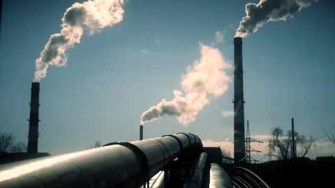 Heating network pipes and smoke rise from big chimney on blue sky. Static shot Stock Footage 107090288