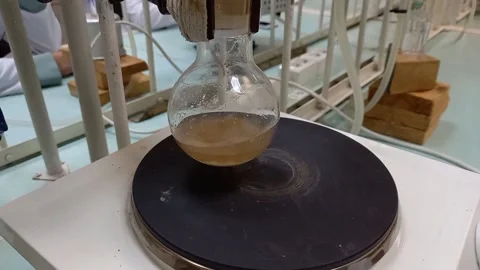 Heating an organic solution on an electric stove in a chemical laboratory. Stockbeeldmateriaal 192776456