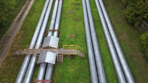 Heating pipes in a green field, showcasing a gradual transition with added Stock Footage 330435732