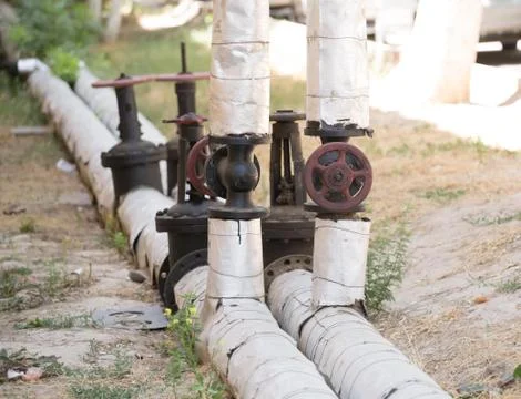 Heating pipes run along the road on the street Stock Photos