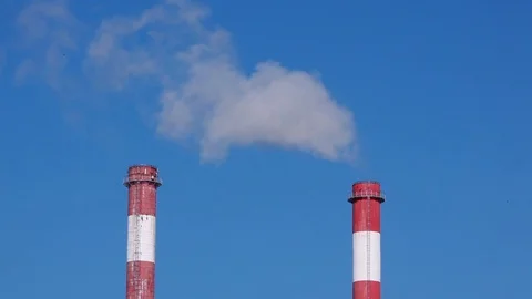 Heating pipes with white smoke work against the blue sky on a bright sunny day Stock Footage 85239415