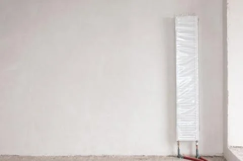 A heating radiator vertically mounted in a new house. New building. Stock Photos