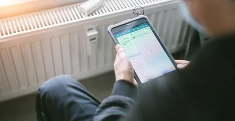 Heating system engineer ist adjusting the digital w-lan network thermometer r Stock Photos