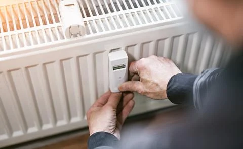 Heating system engineer ist adjusting the digital w-lan network thermometer r Stock Photos