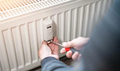 Heating system engineer ist adjusting the digital w-lan network thermometer r Stock Photos